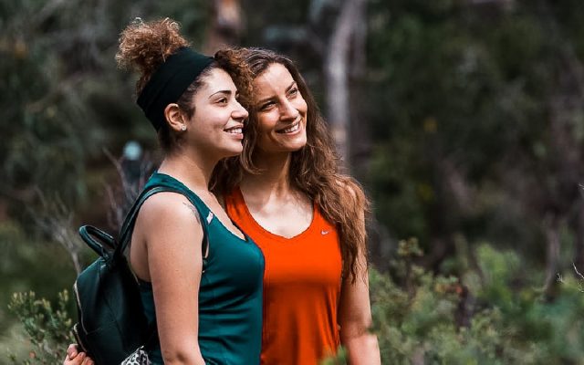 Smiling hikers enjoying a moment on a Perth trail surrounded by native bushland