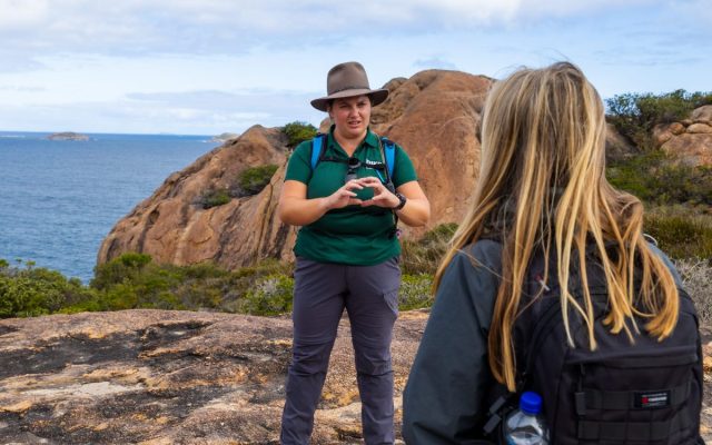 Trail guide briefing a hiker along a coastal trail in Esperance, Western Australia.