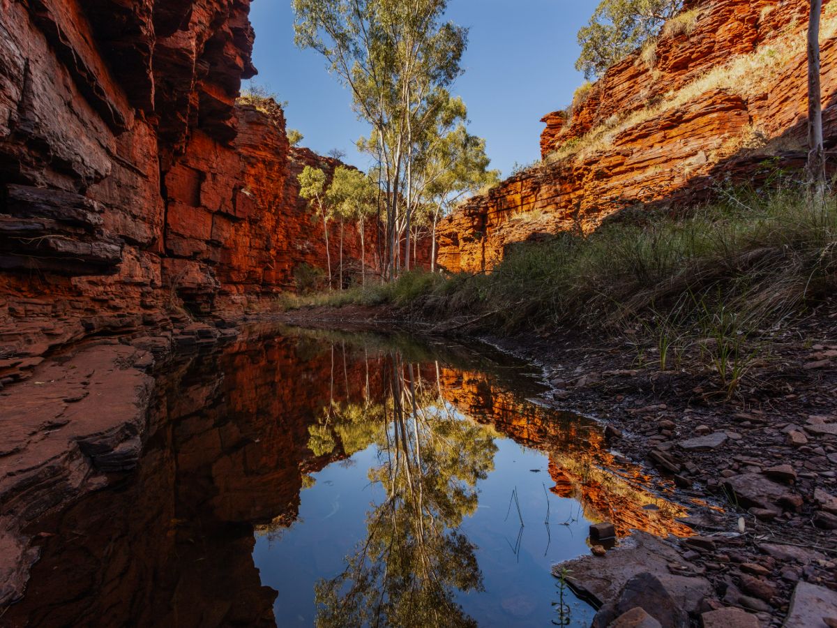 Karijini National Park hiking experience with red rock gorges and reflective waterholes in Western Australia