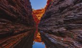 Dramatic red rock gorge reflected in tranquil waters on a Karijini hiking tour in Western Australia